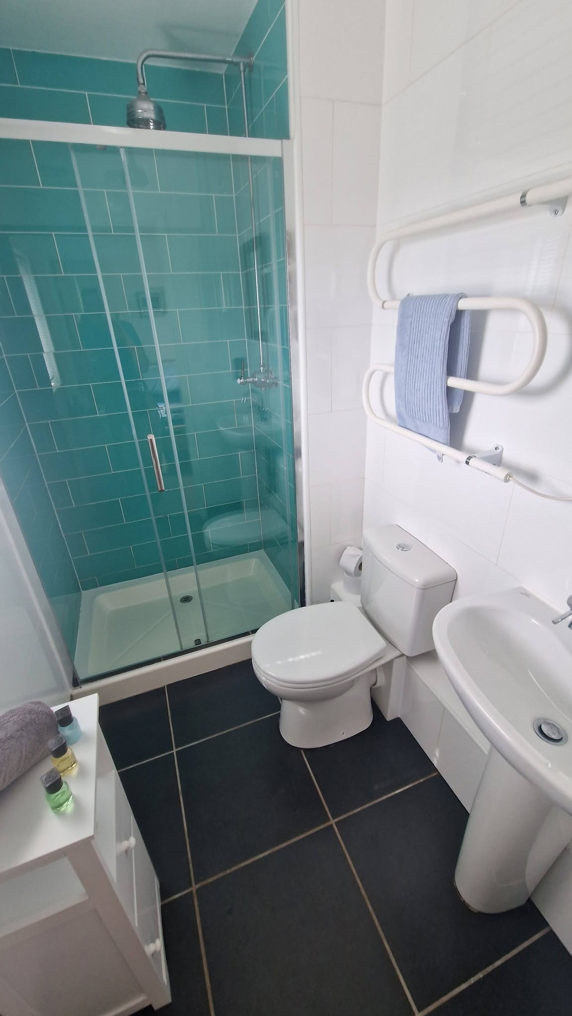 Sparkling clean teal-tiled bathroom after deep cleaning service